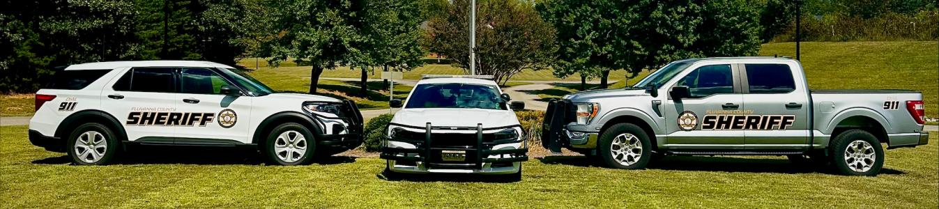 Sheriff's Cars in Front of Half Staff Flag