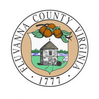 The Fluvanna County official seal depicting a small stone building surrounded by grass and a river. 
