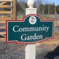 photo of green and red sign for community garden 