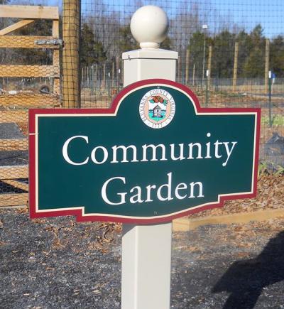 photo of green and red sign for community garden 